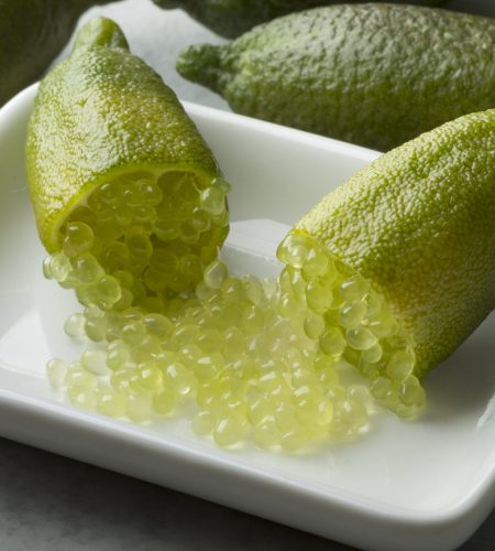 Halved fresh raw green finger lime caviar with sour pearls close up